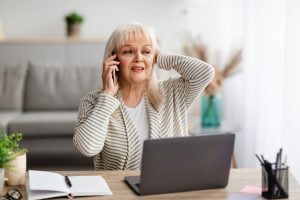 Surprised shocked senior woman talking on mobile phone