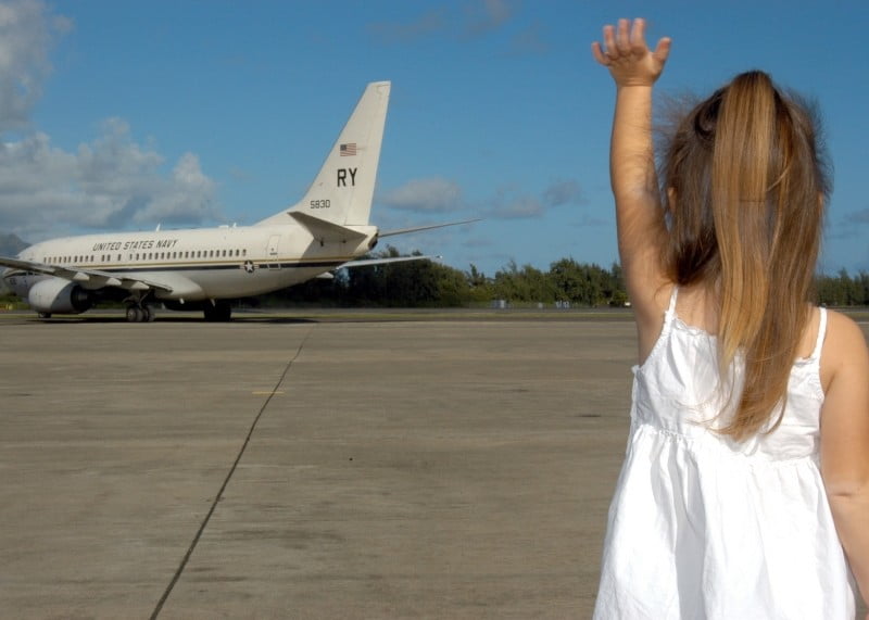 child waving goodbye departure plane family girl